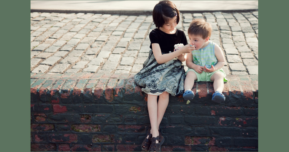 little girl feeding little boy ice cream - child photographer chicago